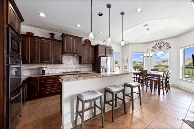 The kitchen is open to the main living and is filled with natural light and incredible views from the back of the home. | Image 14