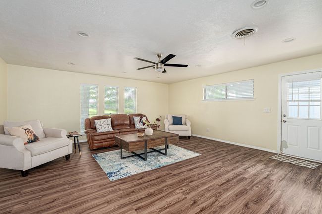 Living room featuring wood finished floors, plenty of natural light, a ceiling fan, and recessed lighting | Image 21