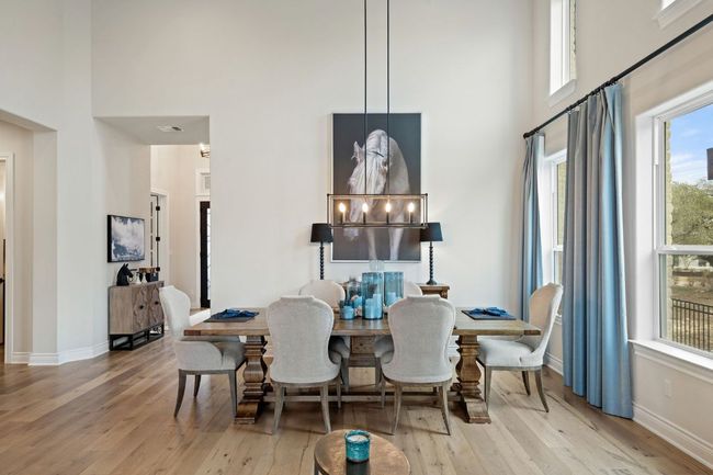 Dining area with wood-type flooring, a high ceiling, and baseboards | Image 21
