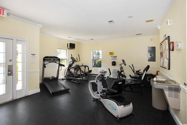 Exercise room with crown molding, electric panel, and baseboards | Image 21