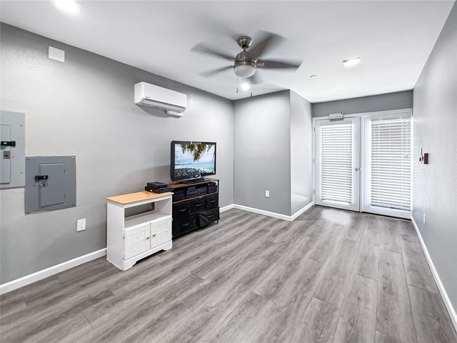 Unfurnished living room with light wood-type flooring, electric panel, and a ceiling fan | Image 24