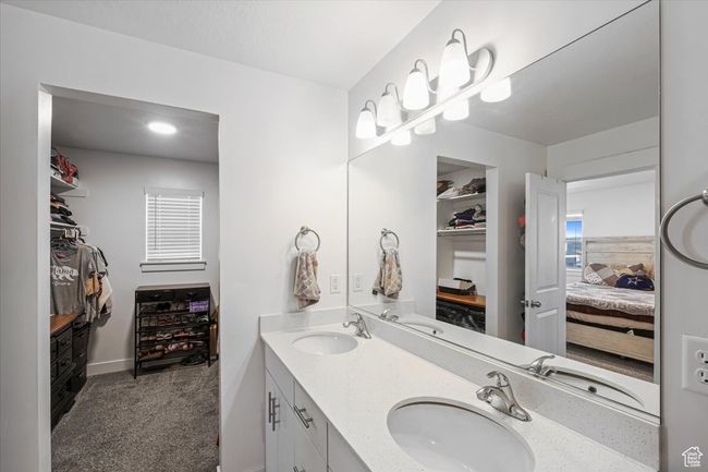 Master bathroom featuring a walk in closet, ensuite bathroom, and a sink | Image 12