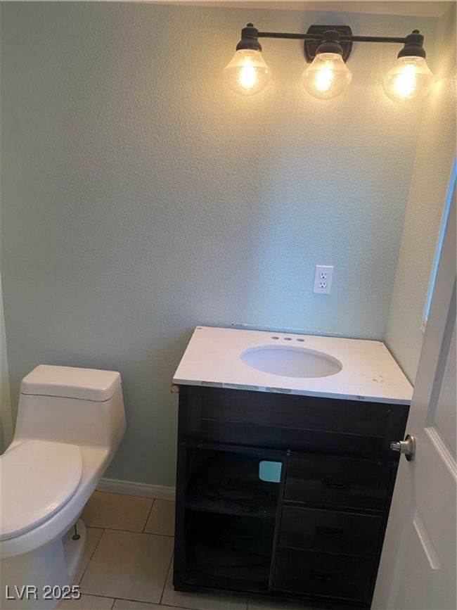 Half bath with toilet, tile patterned flooring, vanity, and baseboards | Image 15