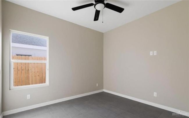 Unfurnished room featuring ceiling fan and a wealth of natural light | Image 8