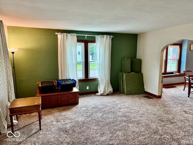 sitting room with arched walkways and carpet floors | Image 7