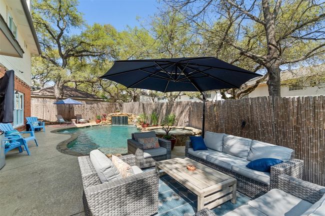 View of swimming pool with a fenced backyard, an outdoor hangout area, a patio area, and a fenced in pool | Image 38