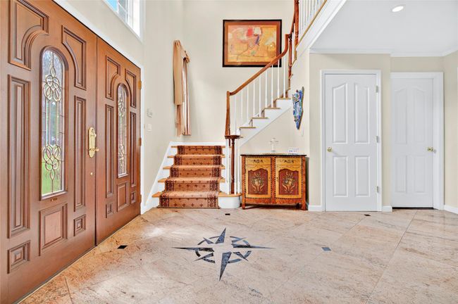 Foyer featuring stairs, a towering ceiling, baseboards, crown molding, and recessed lighting | Image 4