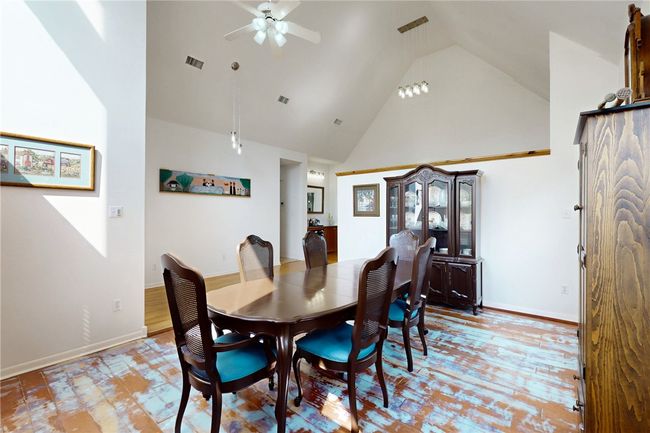 Dining space with baseboards, visible vents, high vaulted ceiling, and ceiling fan | Image 6