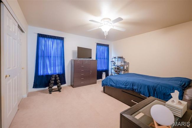Carpeted bedroom with ceiling fan and a closet | Image 35