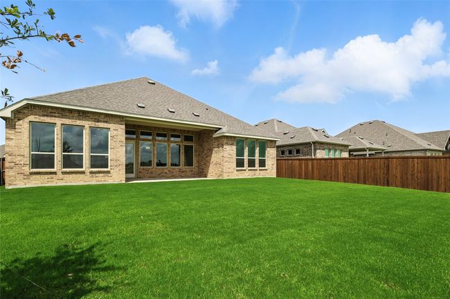 Back of house featuring a fenced backyard, brick siding, and roof with shingles | Image 28