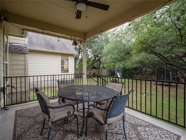 Serene back patio featuring outdoor dining space, a ceiling fan, and a playground | Image 22