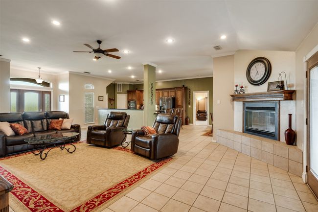Living area featuring light tile patterned flooring, a tile fireplace, ceiling fan, and recessed lighting | Image 5