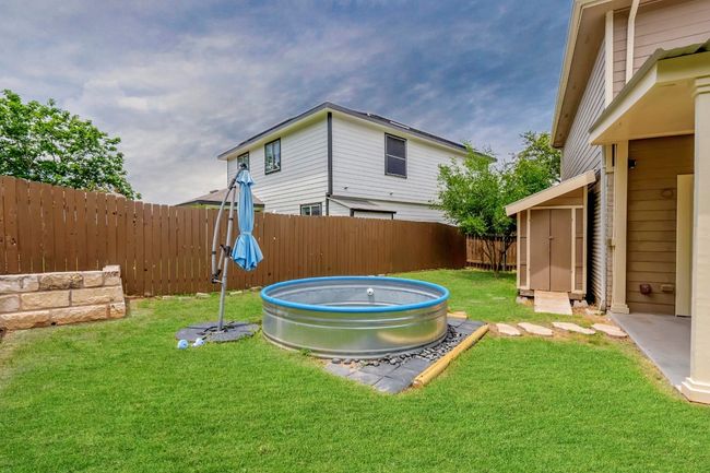 Fenced backyard with a swimming pool and a storage unit | Image 29