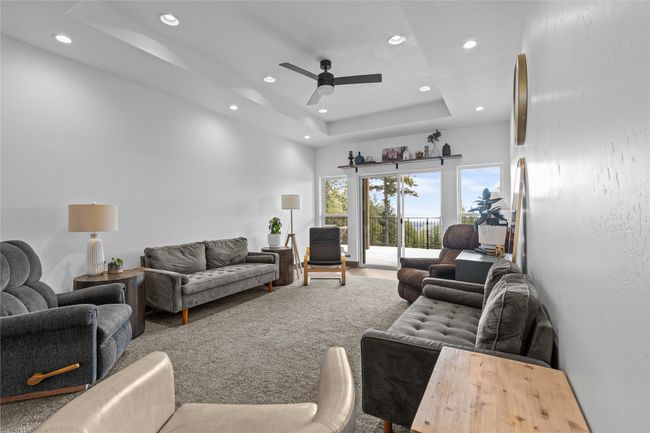 Living room with recessed lighting, a ceiling fan, and a tray ceiling | Image 14