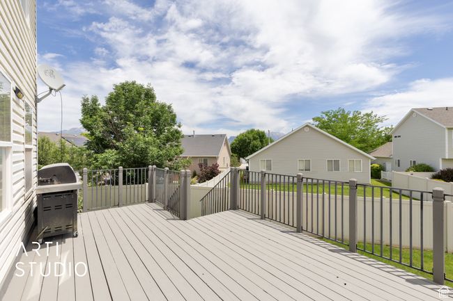 Wooden deck with area for grilling, a residential view, and a fenced backyard | Image 22