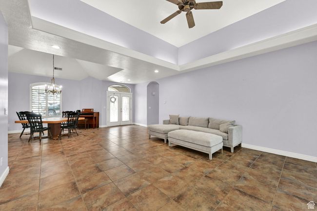 Living room with baseboards, ceiling fan with notable chandelier, arched walkways, and recessed lighting | Image 13