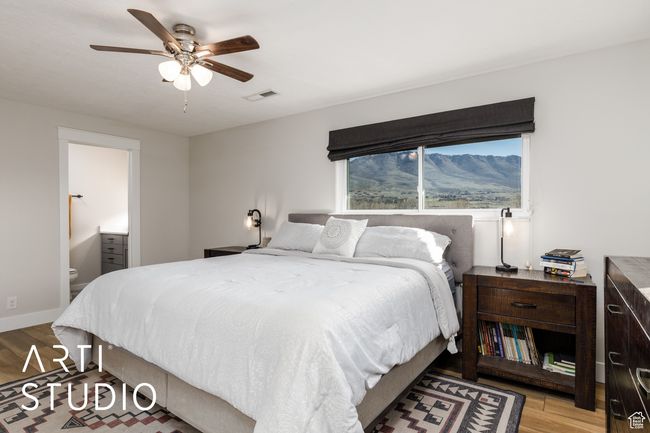 Bedroom featuring wood finished floors, visible vents, ceiling fan, and connected bathroom | Image 24