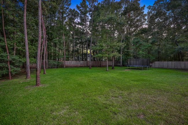 Beyond the pool, this backyard offers room to roam! The vast backyard has a lush green lawn, perfect for play, pets, or future enhancements. | Image 47