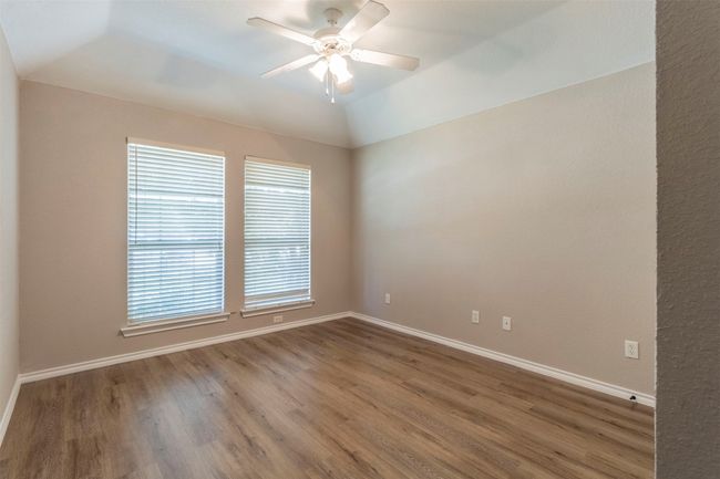 Unfurnished room featuring baseboards, a ceiling fan, wood finished floors, and lofted ceiling | Image 6