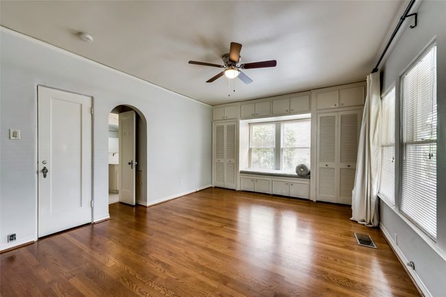 Unfurnished room featuring arched walkways, a ceiling fan, wood finished floors, and a smoke detector | Image 17