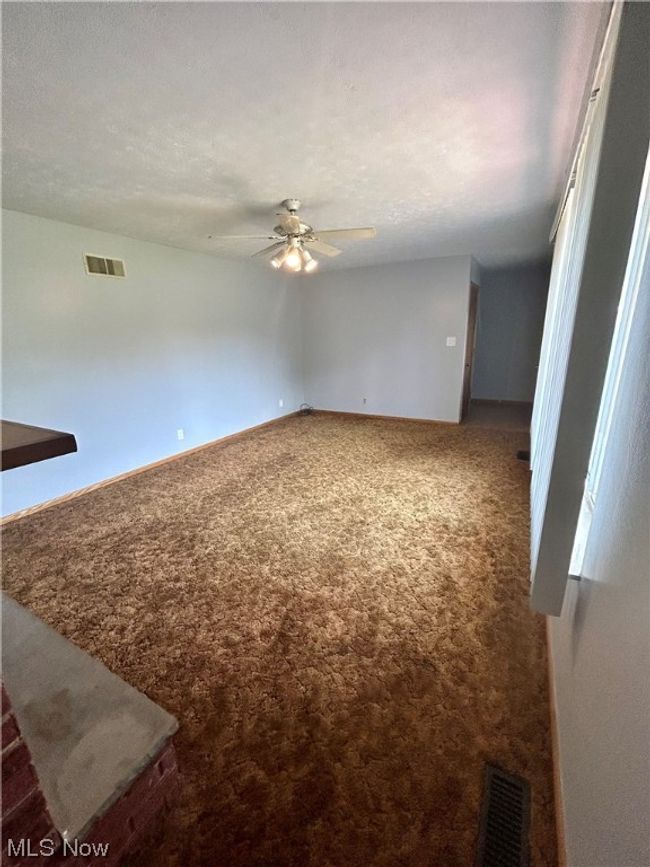 Carpeted empty room featuring ceiling fan | Image 6