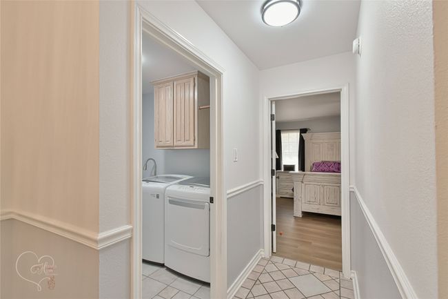 Laundry room with independent washer and dryer, light tile patterned flooring, and cabinet space | Image 19