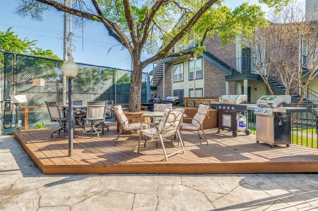 Wooden terrace with outdoor dining area, fence, and grilling area | Image 22