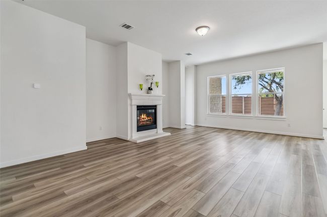 Unfurnished living room with light wood finished floors and a glass covered fireplace | Image 6