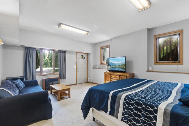Lower-level 5th bedroom with private entrance, abundant natural light, and generous space—ideal for guests, a home office, or potential in-law suite conversion. | Image 35