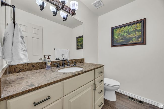Bathroom featuring visible vents, baseboards, toilet, and wood finished floors | Image 17