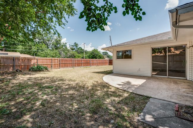 Fenced backyard with a patio area | Image 22