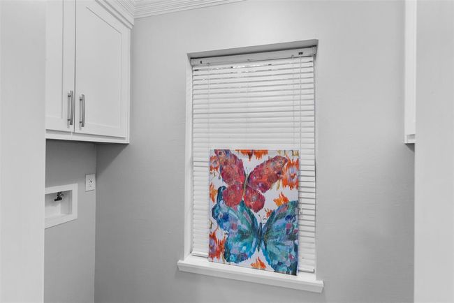 The laundry room is conveniently located near the kitchen. | Image 11