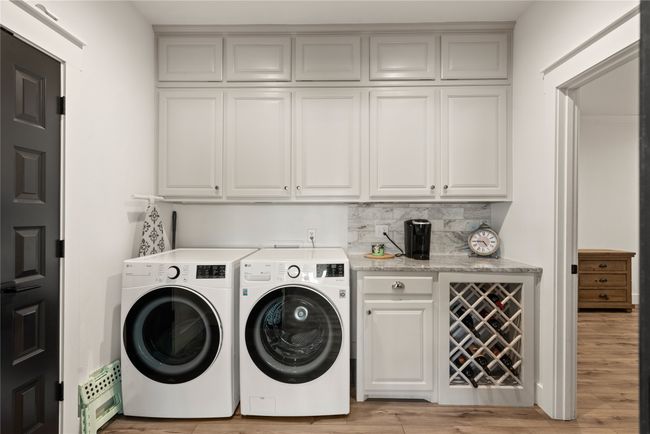 Washroom with washing machine and clothes dryer, cabinet space, and light wood-type flooring | Image 21