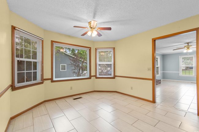 Empty room featuring a ceiling fan, a textured ceiling, and light tile patterned floors | Image 9