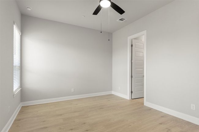 Empty room featuring light wood-style flooring, a ceiling fan, and healthy amount of natural light | Image 26