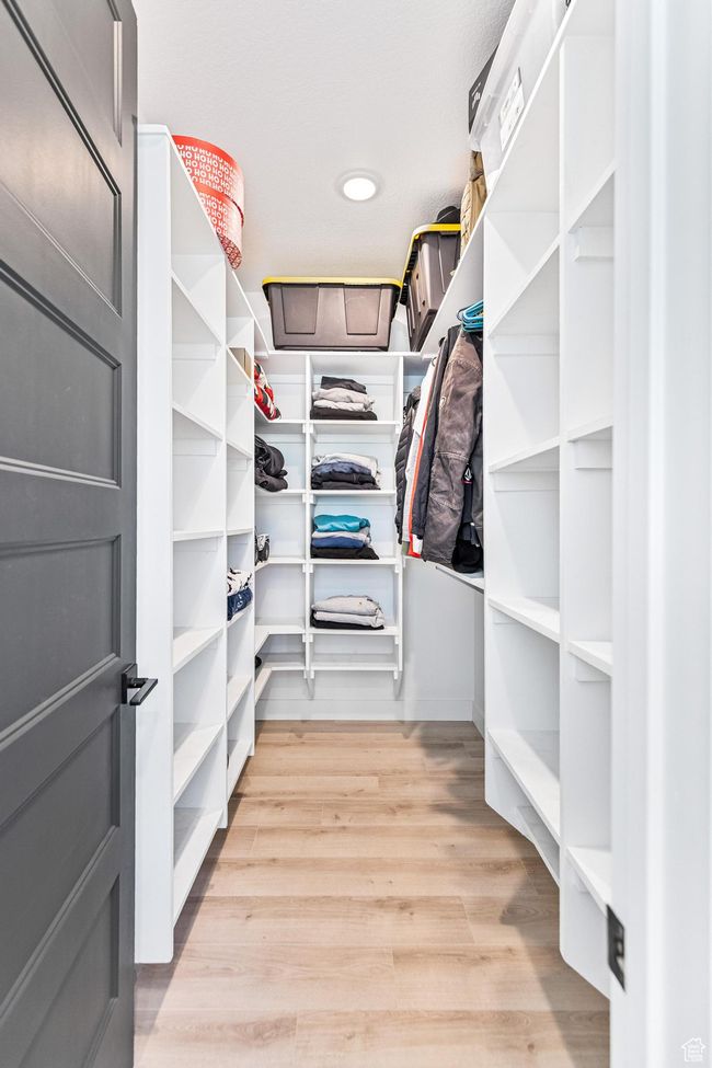 Spacious closet with light wood-type flooring | Image 52