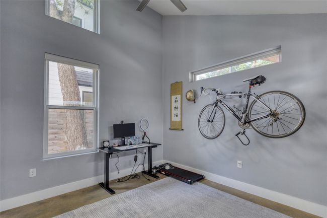 Office area featuring a high ceiling, concrete flooring, and baseboards | Image 18