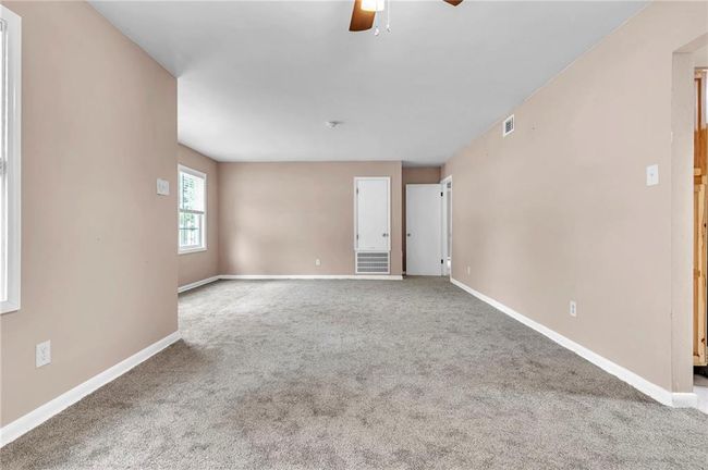 Spare room featuring ceiling fan, carpet floors, visible vents, and baseboards | Image 13
