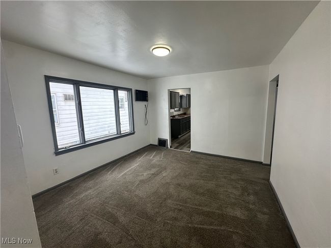 Unfurnished room with dark carpet, baseboards, and visible vents | Image 23