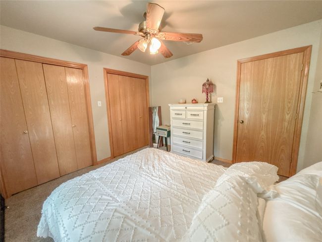 Bedroom featuring two closets, ceiling fan, and carpet | Image 20