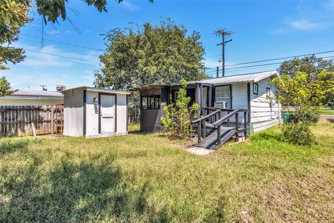 Back of house featuring a storage unit and a metal roof | Image 39
