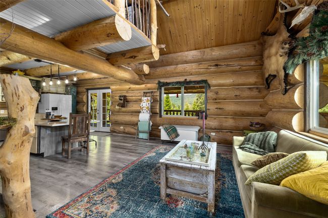 Living room featuring wood finished floors, rustic walls, and wood ceiling with exposed beams | Image 11