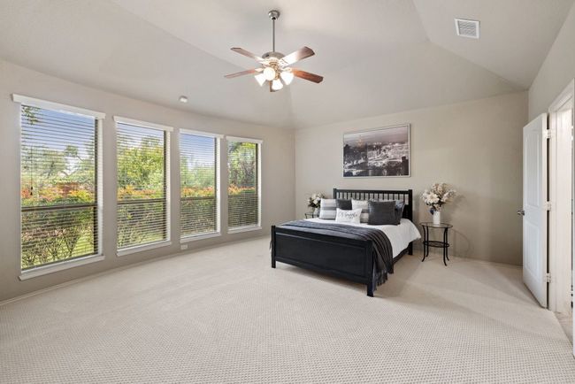 Bedroom featuring light colored carpet, vaulted ceiling, and a ceiling fan | Image 15