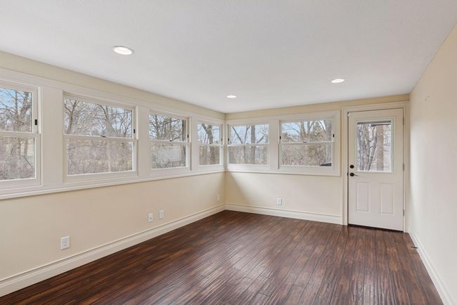 Main level 4 season porch is bright and sunny and looks out to backyard. | Image 35