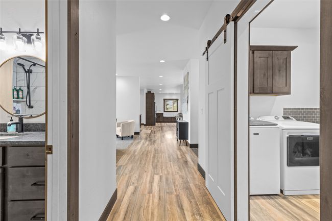 Hall featuring recessed lighting, washing machine and clothes dryer, a barn door, and light wood-type flooring | Image 38