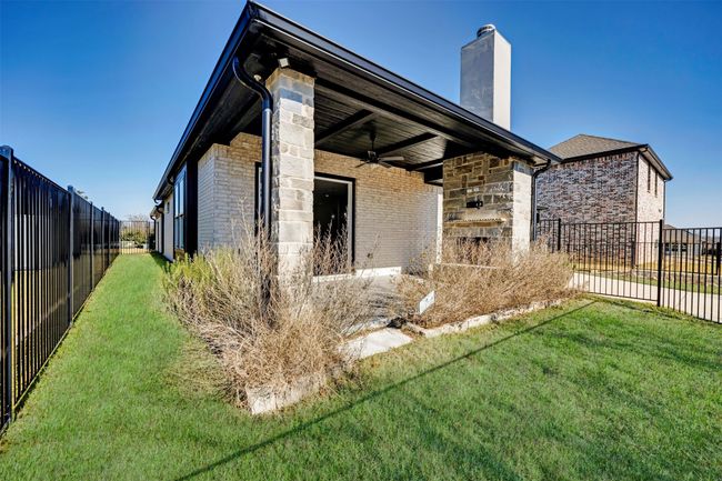 View of home's exterior with a yard, brick siding, and a ceiling fan | Image 20