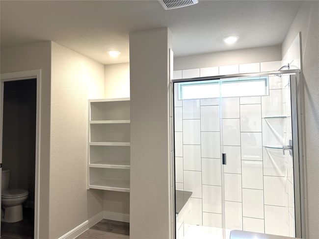 Full bath featuring a shower stall and wood finished floors | Image 11