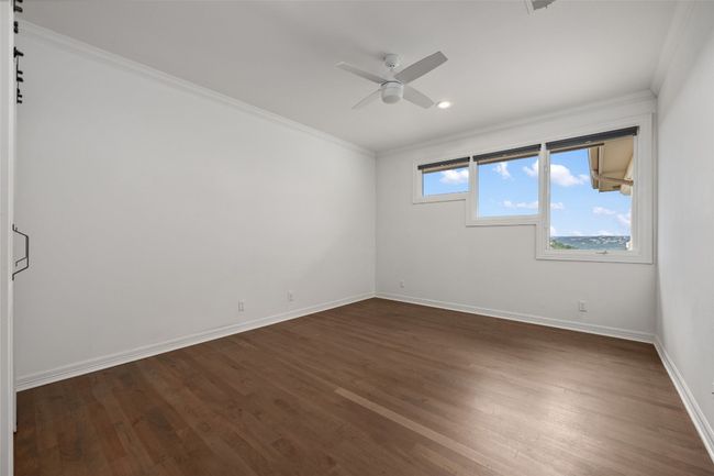 Unfurnished room featuring crown molding, a ceiling fan, baseboards, dark wood finished floors, and recessed lighting | Image 20