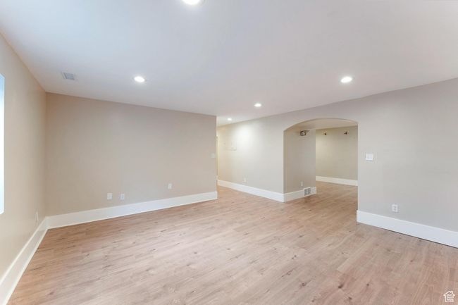 Basement family room featuring arched walkways, recessed lighting, and light wood-type flooring | Image 30