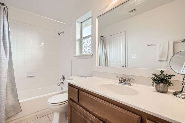 Bathroom featuring vanity, shower / bath combo, toilet, and tile patterned floors | Image 16